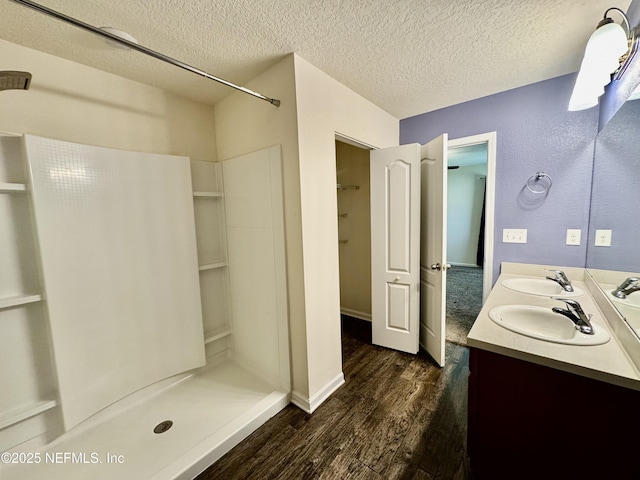 full bathroom with wood finished floors, a shower, and a sink