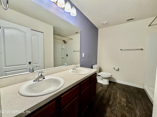 full bathroom featuring toilet, wood finished floors, visible vents, and a sink