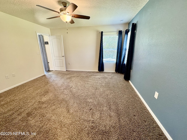 carpeted empty room with baseboards, a textured ceiling, a ceiling fan, and a textured wall