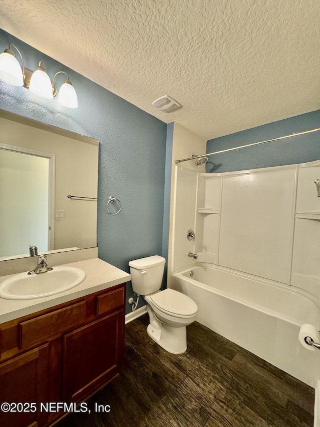 bathroom featuring vanity, wood finished floors, visible vents, a textured ceiling, and toilet