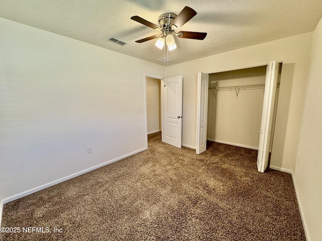 unfurnished bedroom with baseboards, visible vents, a textured ceiling, and carpet