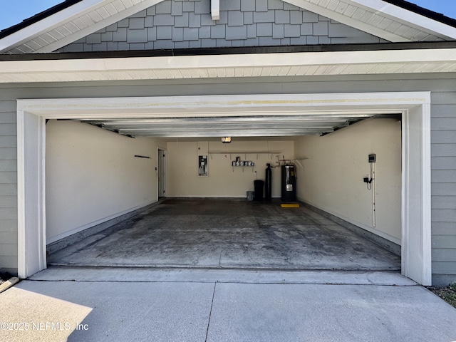 garage featuring electric panel, electric water heater, and concrete driveway
