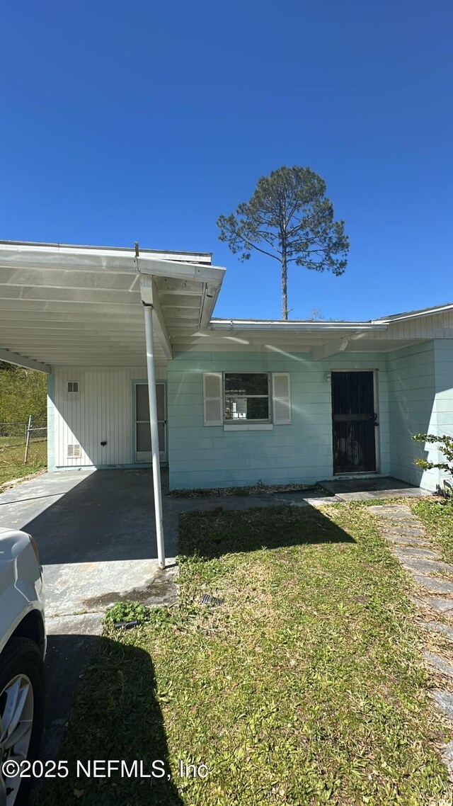 9504 Flechette Ave, Jacksonville, FL 32208 - exterior space with an attached carport, concrete driveway, and a front yard