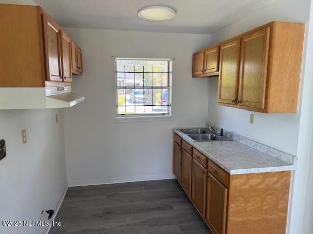 9504 Flechette Ave, Jacksonville, FL 32208 - kitchen with a sink, dark wood-style floors, brown cabinetry, light countertops, and baseboards