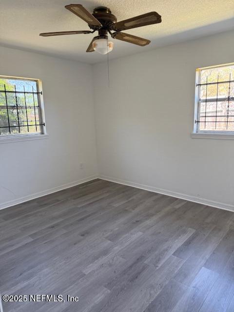 9504 Flechette Ave, Jacksonville, FL 32208 - spare room with a textured ceiling, baseboards, dark wood-style flooring, and ceiling fan