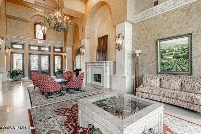 9745 Touchton Rd Unit 1629, Jacksonville, FL 32246 - living room featuring an inviting chandelier, a fireplace, french doors, a high ceiling, and visible vents