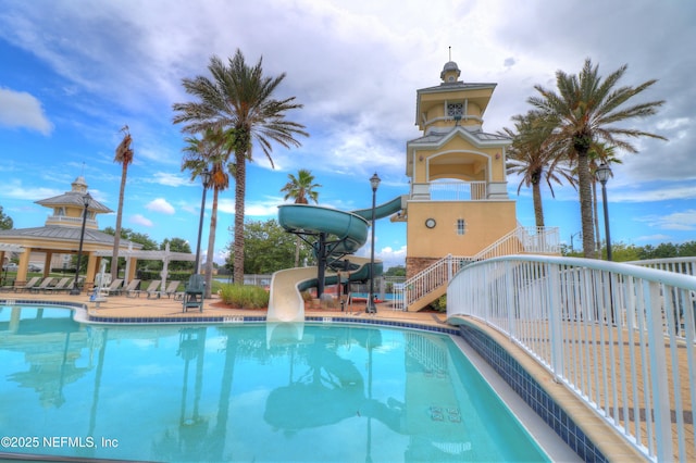 pool featuring a water slide, a gazebo, and stairway