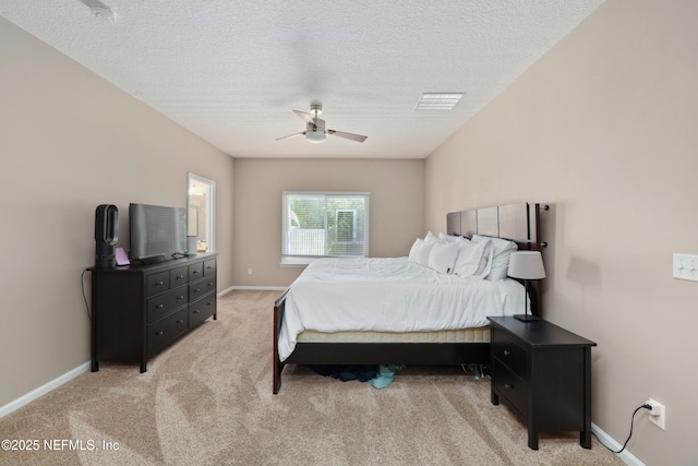 bedroom featuring baseboards, a ceiling fan, a textured ceiling, and light colored carpet