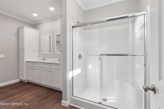 2939 Fitzgerald St, Jacksonville, FL 32254 - bathroom with crown molding, a sink, a shower stall, wood finished floors, and double vanity