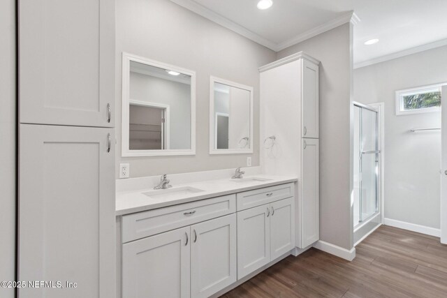 2939 Fitzgerald St, Jacksonville, FL 32254 - bathroom featuring ornamental molding, a sink, a shower stall, and wood finished floors