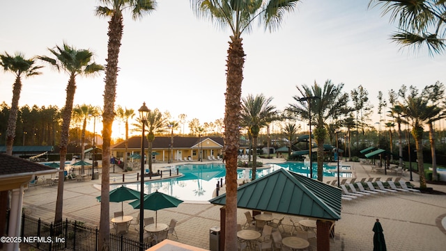community pool with fence, a patio area, and a water slide