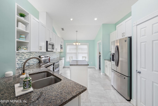 kitchen featuring stainless steel appliances, open shelves, a sink, a chandelier, and white cabinetry