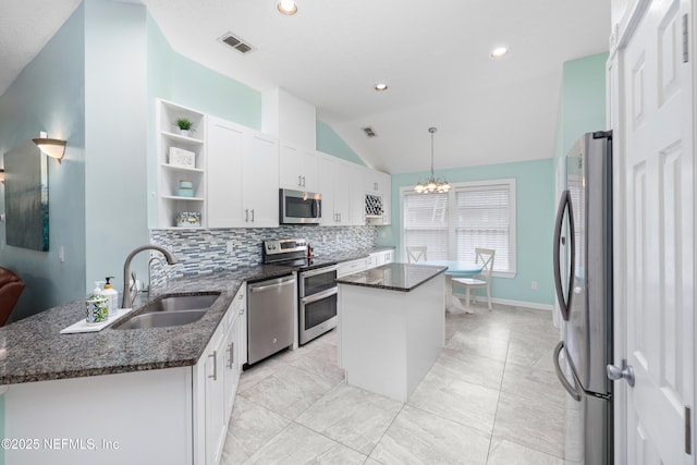 kitchen featuring appliances with stainless steel finishes, a sink, open shelves, a kitchen island, and white cabinets