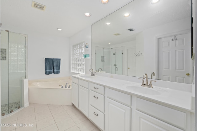 bathroom with recessed lighting, a shower stall, double vanity, a bath, and tile patterned floors