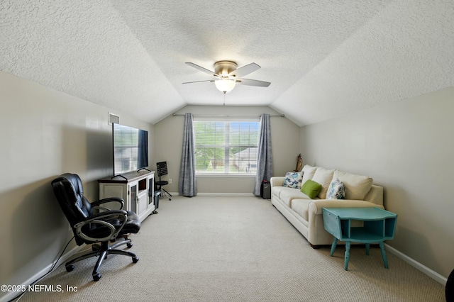 office space with vaulted ceiling, baseboards, carpet floors, ceiling fan, and a textured ceiling
