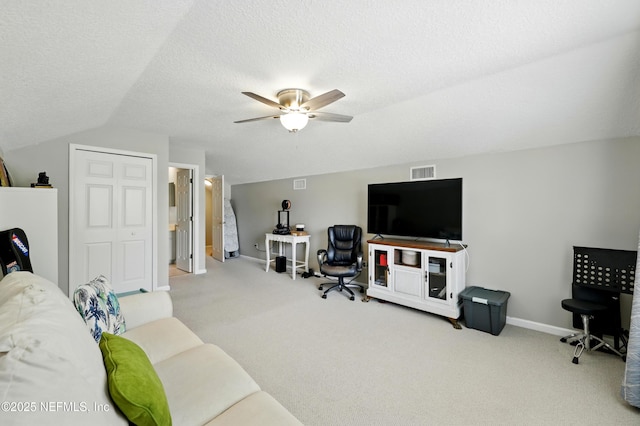 living area featuring carpet floors, ceiling fan, baseboards, lofted ceiling, and a textured ceiling