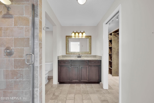 2200 Ocean Dr Unit 4A, Jacksonville Beach, FL 32050 - bathroom with a shower stall, vanity, baseboards, toilet, and a spacious closet