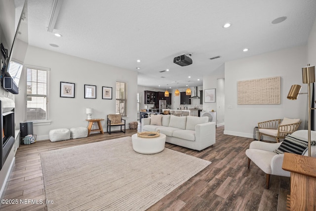 living room featuring dark wood-style floors, visible vents, baseboards, and recessed lighting