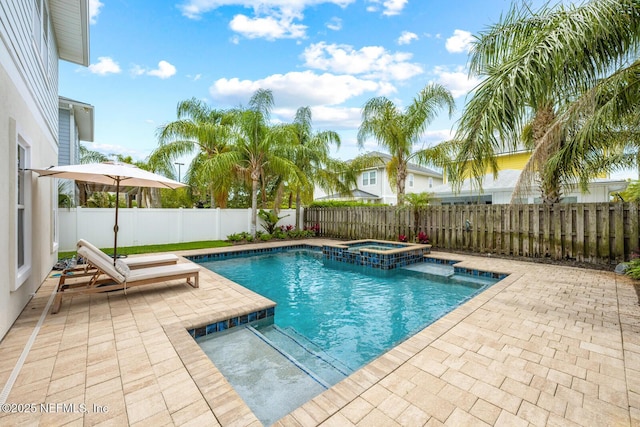 view of pool featuring a fenced backyard, a pool with connected hot tub, and a patio