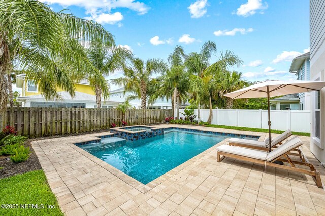 view of swimming pool featuring a fenced backyard, a pool with connected hot tub, and a patio