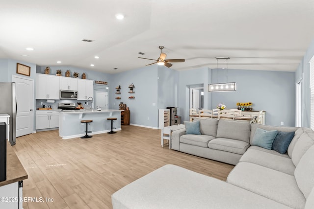 208 Seville Pkwy, Saint Augustine, FL 32086 - living room featuring vaulted ceiling, light wood finished floors, baseboards, visible vents, and ceiling fan