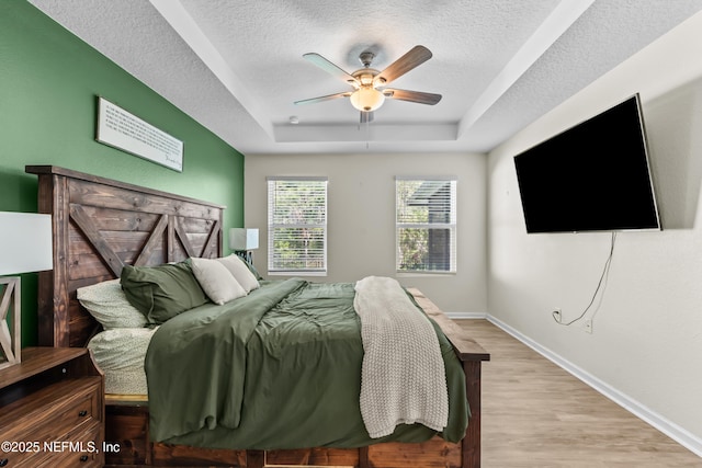 208 Seville Pkwy, Saint Augustine, FL 32086 - bedroom with a raised ceiling, a textured ceiling, baseboards, and wood finished floors