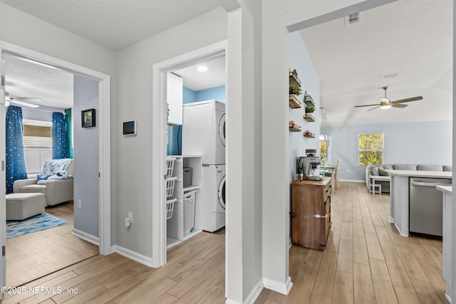 208 Seville Pkwy, Saint Augustine, FL 32086 - hall with stacked washer and dryer, a textured ceiling, visible vents, and wood finish floors