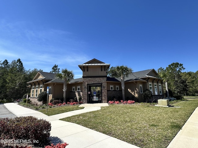 208 Seville Pkwy, Saint Augustine, FL 32086 - view of front of home featuring stone siding, board and batten siding, and a front yard