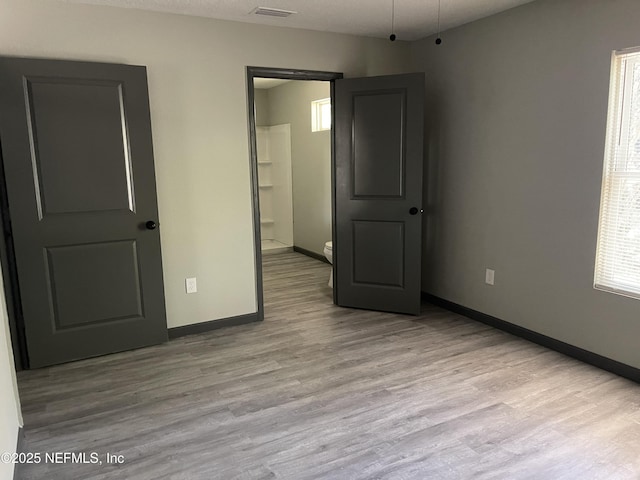 1517 W 33rd Rd, St, Jacksonville, FL 32209 - unfurnished bedroom featuring connected bathroom, visible vents, baseboards, and wood finished floors