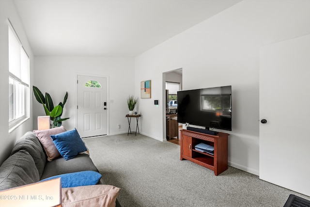 living area featuring lofted ceiling, carpet floors, and baseboards