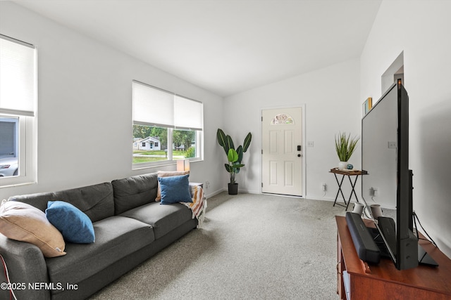 carpeted living area featuring vaulted ceiling and baseboards
