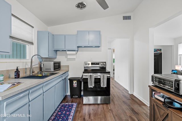 kitchen with stainless steel appliances, a sink, dark wood-style floors, visible vents, and lofted ceiling