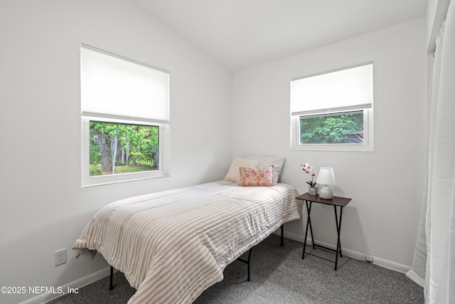 carpeted bedroom with vaulted ceiling and baseboards