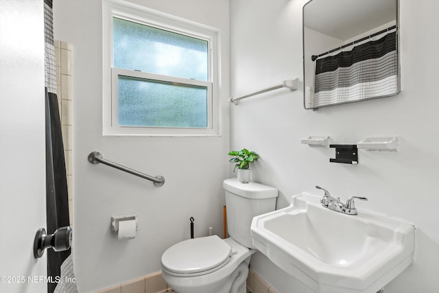 bathroom with toilet, a sink, and curtained shower
