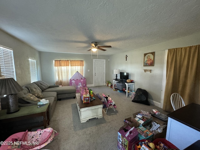 living area with ceiling fan, carpet, baseboards, and a textured ceiling
