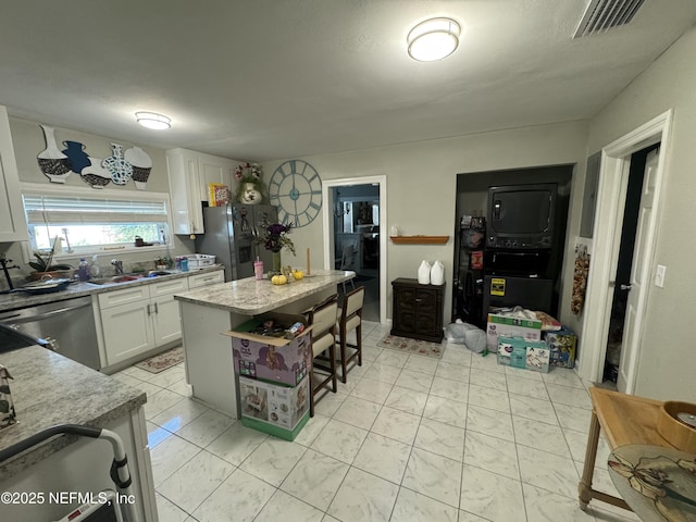 kitchen with white cabinets, visible vents, stainless steel appliances, marble finish floor, and a sink