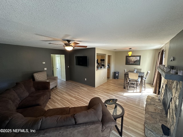 11726 Tanager Dr, Jacksonville, FL 32225 - living area with a fireplace, a ceiling fan, light wood finished floors, and a textured ceiling
