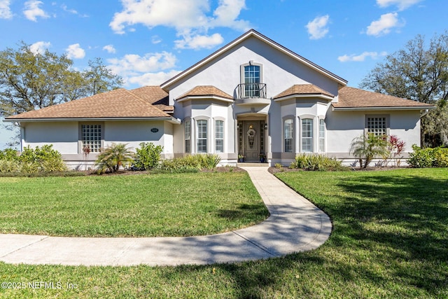 5698 Grand Cayman Rd, Jacksonville, FL 32226 - mediterranean / spanish-style home featuring a front lawn, a balcony, and stucco siding