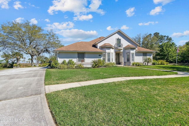 5698 Grand Cayman Rd, Jacksonville, FL 32226 - view of front facade with a front yard, driveway, and stucco siding