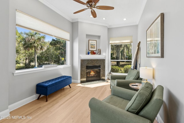 5698 Grand Cayman Rd, Jacksonville, FL 32226 - living area featuring a fireplace with flush hearth, ornamental molding, wood finished floors, baseboards, and ceiling fan