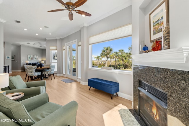 5698 Grand Cayman Rd, Jacksonville, FL 32226 - living room featuring visible vents, light wood-style flooring, baseboards, ceiling fan, and a tile fireplace