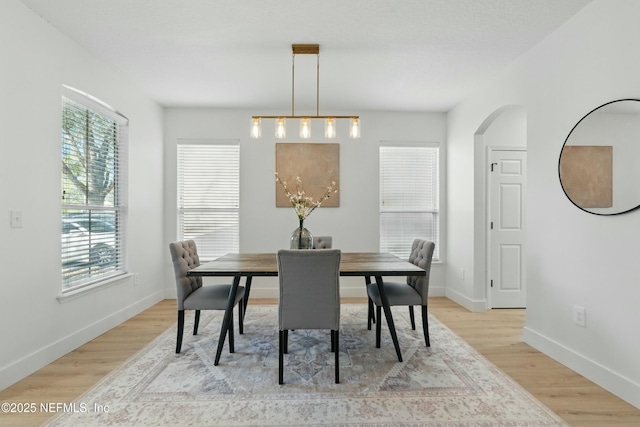 3852 Westridge Dr, Orange Park, FL 32065 - dining area with arched walkways, light wood-style flooring, and baseboards