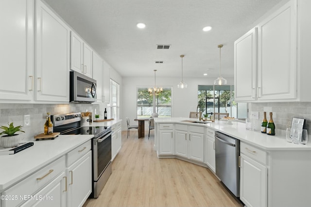 3852 Westridge Dr, Orange Park, FL 32065 - kitchen with white cabinets, light wood-style floors, and stainless steel appliances