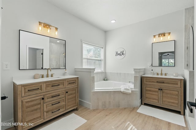 3852 Westridge Dr, Orange Park, FL 32065 - bathroom featuring a sink, a garden tub, two vanities, and wood finished floors