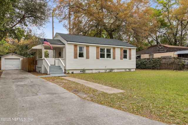 1171 Scotten Rd, Jacksonville, FL 32205 - view of front facade with fence, a detached garage, a front lawn, driveway, and an outbuilding