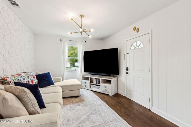 1171 Scotten Rd, Jacksonville, FL 32205 - living room featuring dark wood-style floors, visible vents, and an inviting chandelier