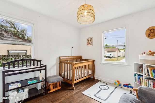 1171 Scotten Rd, Jacksonville, FL 32205 - bedroom featuring a crib, baseboards, and wood finished floors