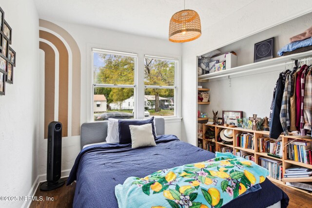 1171 Scotten Rd, Jacksonville, FL 32205 - bedroom featuring baseboards, arched walkways, and wood finished floors