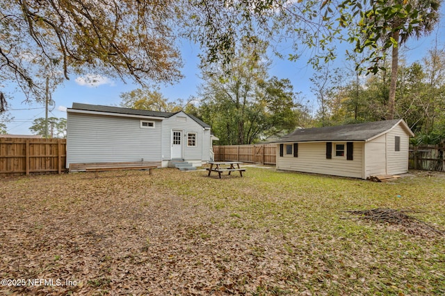 1171 Scotten Rd, Jacksonville, FL 32205 - rear view of property with an outbuilding, a fenced backyard, a yard, and entry steps