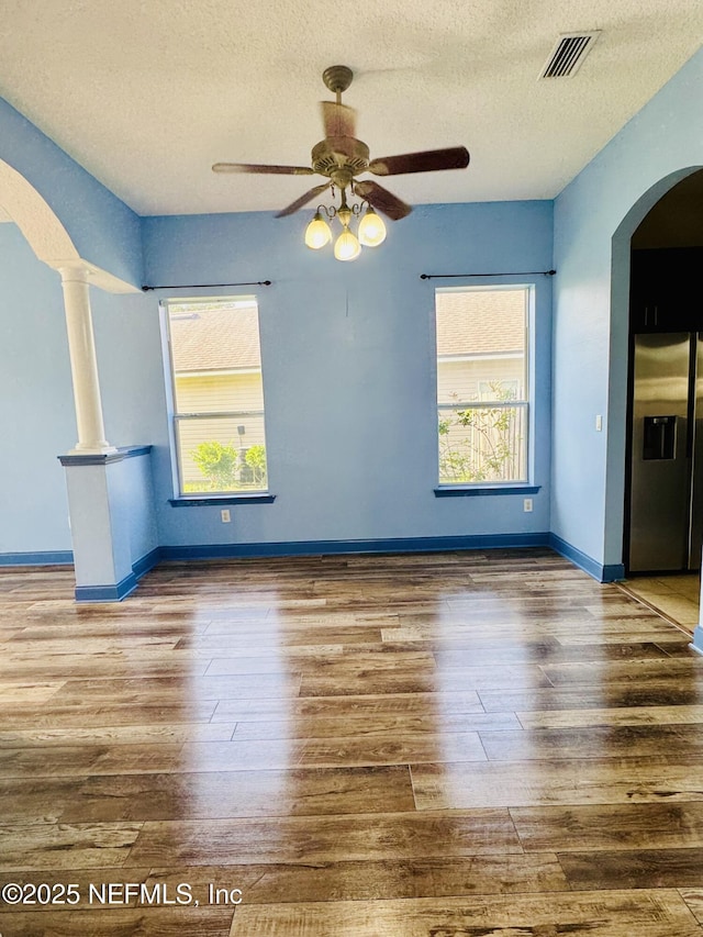 11770 Huckleberry Trl E, Macclenny, FL 32063 - unfurnished room featuring arched walkways, ceiling fan, a textured ceiling, wood finished floors, and baseboards